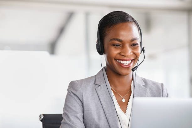 Staff member with a headset smiling at her screen